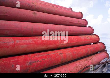 Verrostete Metallrohre aus Eisenstahl stapeln ein industrielles Feld Stockfoto