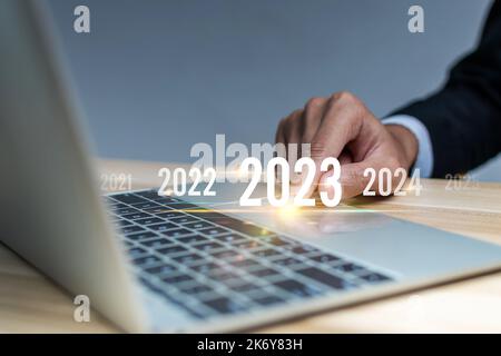 2023. Geschäftsmann Hand berühren und zeigen auf Jahr 2023 mit digitalen Laptop-Computer, Ziel, Änderung von 2022 auf 2023, Strategie, Finanzen, inve Stockfoto