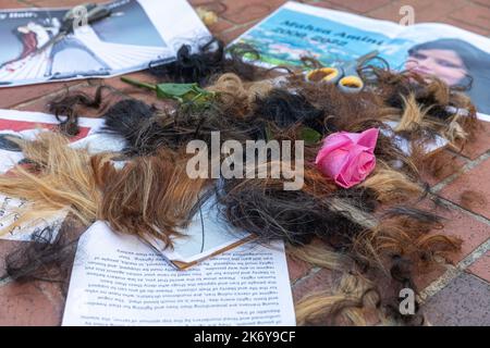 Portland, Usa. 15. Oktober 2022. Beschnittene Haarsträhnen und eine Rosenblume als Symbol für die Unterstützung der Rechte und Freiheiten iranischer Frauen während der Kundgebung. In der Innenstadt von Portland versammelten sich Hunderte von Menschen, um das Bewusstsein für ein riesiges Frauenrechtsproblem im Iran zu schärfen. Sie kamen zusammen, um auf den Tod der 22-jährigen Mahsa Amini aufmerksam zu machen, die letzten Monat im Iran starb, nachdem die Polizei sie verhaftet hatte, weil sie einen Hijab, einen traditionellen Kopftuch, getragen von einigen muslimischen Frauen, unrechtmäßig trug. Kredit: SOPA Images Limited/Alamy Live Nachrichten Stockfoto