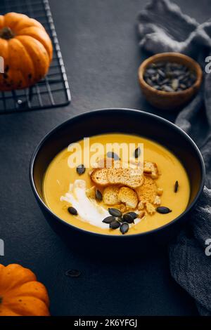 Kürbiscremesuppe mit Croutons auf dunklem Hintergrund Stockfoto