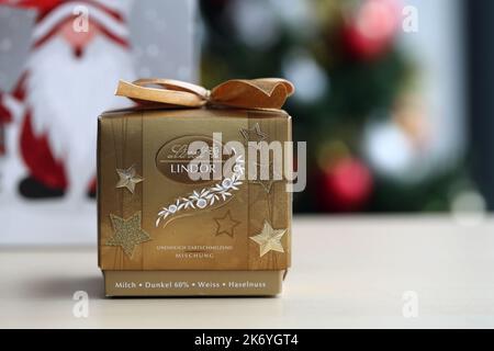 Espoo, Finnland, Dez 2020: Goldene dekorative Geschenkbox gefüllt mit Lindt Lindor Kugeln - Schweizer Luxus-Schokolade perfekt für Weihnachten und Genießen. Stockfoto