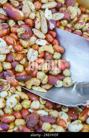 Holzkiste mit einer Auswahl an frittierten, salzigen und trockenen Früchten. Ausgestellt am Straßenmarktstand Stockfoto
