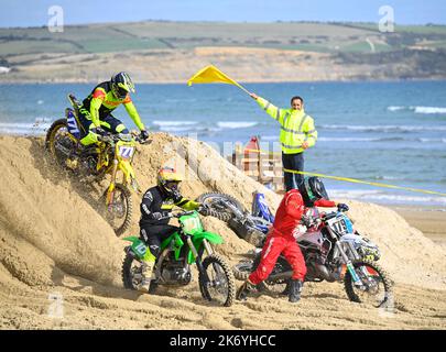 STRANDRENNEN IN WEYMOUTH - 9. OKTOBER 2022: Motorradfahrer fahren am Strand von Weymouth, Dorset, Großbritannien Stockfoto