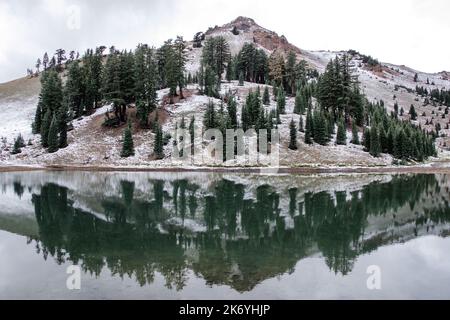 Vulkanischer See in den verschneiten Bergen. Ridge Lakes im Lassen Volcanic National Park in Kalifornien. Reflektierender Bergsee Stockfoto