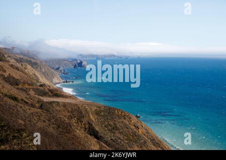 Atemberaubende Aussicht auf die Küste in Kalifornien. Meeresküste mit klarem Himmel und himmelblauem Wasser an der Westküste. Historische Route California 1 Stockfoto