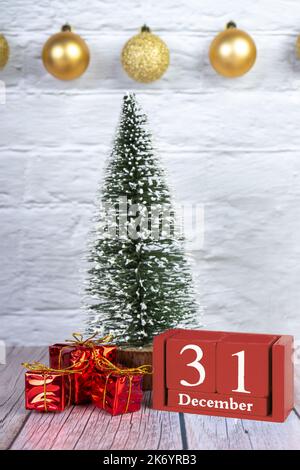 Dekorativer Weihnachtsbaum, Geschenkboxen und roter ewiger Holzkalender mit Datum auf weißem Holzhintergrund. Banner, Header, Neujahrshintergrund mit Stockfoto