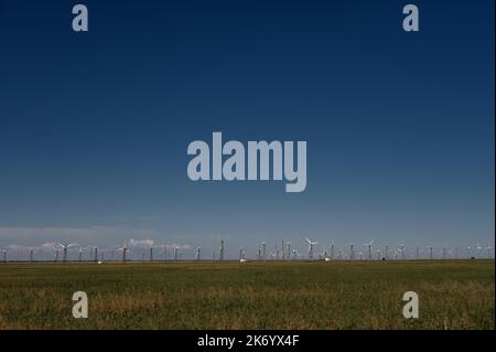 Luftaufnahme über die Farmlandschaft und Windkraftanlagen, die saubere erneuerbare Energien erzeugen. Stockfoto