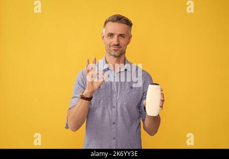 Guy wählen Shampoo-Flasche oder Haarspülung. Tägliche Gewohnheiten und persönliche Pflege. Stockfoto