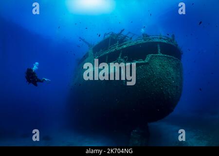 Ein Taucher erkundet ein großes Schiffswrack auf dem Boden der Ägäis Stockfoto