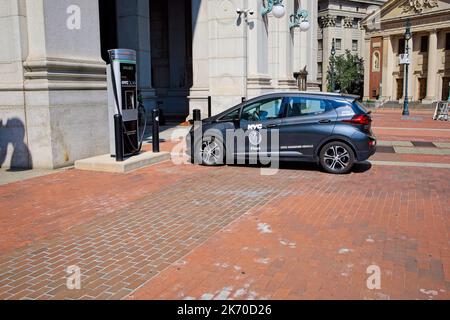 New York, NY, USA - 16. Oktober 2022: Ein kleines staatliches Elektrofahrzeug, das in der Nähe einer Ladestation im New Yorker Rathaus geparkt ist Stockfoto