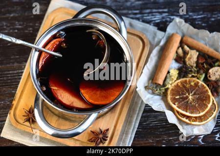 Kochtopf mit heißem Glühwein. Gewürze und Zitrusfrüchte. Weihnachtsgetränke. Kochen Glühwein. Stockfoto