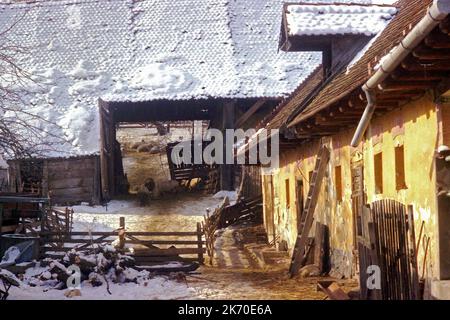 Sibiu County, Rumänien, 2000. Ein traditionelles Anwesen mit großer Scheune und Schuppen im Winter. Stockfoto