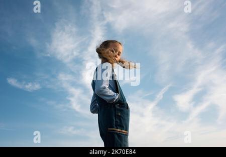 Das Porträt eines Mädchens stand mit ihren Haaren, die im Wind wehten Stockfoto