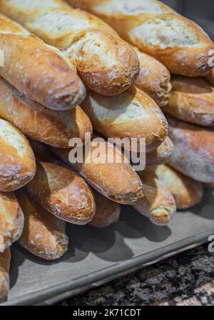 Frisch gebackene französische Baguettes in einer Bäckerei. Draufsicht, Kopierbereich. Köstliches frisch gebackenes Brot. Niemand, selektiver Fokus Stockfoto