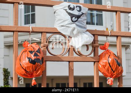 Künstliche Kürbisköpfe aus einer Plastiktüte am Zaun Haus im Hintergrund. Stockfoto