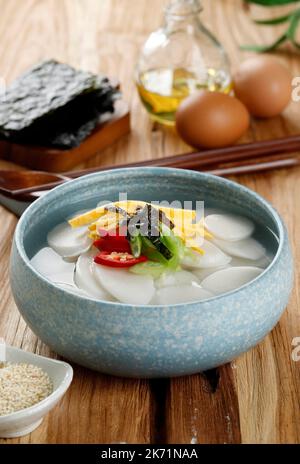 Tteokguk, koreanische Aufschnitt-Reiskuchensuppe, ovaler Reiskuchen in klarer Brühe. Traditionelles Mondlandestegericht. Reine Rinderbrühe ist am häufigsten Stockfoto