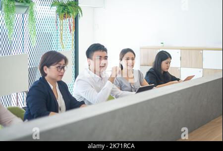 Geschäftsleute, die in einer Reihe an einer Schulung in einem CO-Arbeitsbereich teilnehmen. Stockfoto