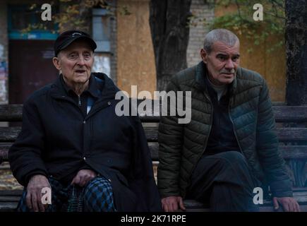 Bakhmut, Ukraine. 9. Oktober 2022. Yara (R) sah mit seinem 85-jährigen Vater sitzen, der Schwierigkeiten beim Gehen in Bakhmut hat. Trotz der Vorrückung ukrainischer Truppen im Osten und Süden der Ukraine ist die Stadt Bakhmut im Osten von Donezk einem intensiven Widerstand ausgesetzt. Russland hat in der Stadt Gewinne erzielt. Die Stadt hat Tag und Nacht andauernden Beschuss erlebt und die Stadt ist derzeit ohne fließendes Wasser und Strom. (Bild: © Ashley Chan/SOPA Images via ZUMA Press Wire) Stockfoto