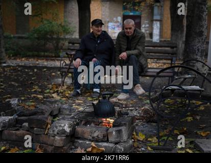 Bakhmut, Ukraine. 9. Oktober 2022. Yara (R) sah mit seinem 85-jährigen Vater sitzen, der Schwierigkeiten beim Gehen in Bakhmut hat. Trotz der Vorrückung ukrainischer Truppen im Osten und Süden der Ukraine ist die Stadt Bakhmut im Osten von Donezk einem intensiven Widerstand ausgesetzt. Russland hat in der Stadt Gewinne erzielt. Die Stadt hat Tag und Nacht andauernden Beschuss erlebt und die Stadt ist derzeit ohne fließendes Wasser und Strom. (Bild: © Ashley Chan/SOPA Images via ZUMA Press Wire) Stockfoto