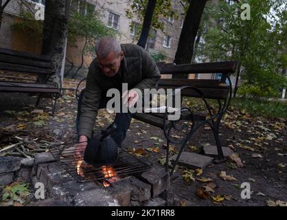 Bakhmut, Ukraine. 9. Oktober 2022. Yana, Bewohner von Bakhmut, sah, wie sie ein Feuer machte, um Tee zu kochen. Trotz der Vorrückung ukrainischer Truppen im Osten und Süden der Ukraine ist die Stadt Bakhmut im Osten von Donezk einem intensiven Widerstand ausgesetzt. Russland hat in der Stadt Gewinne erzielt. Die Stadt hat Tag und Nacht andauernden Beschuss erlebt und die Stadt ist derzeit ohne fließendes Wasser und Strom. (Bild: © Ashley Chan/SOPA Images via ZUMA Press Wire) Stockfoto