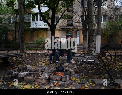 Bakhmut, Ukraine. 9. Oktober 2022. Yara (R) sah mit seinem 85-jährigen Vater sitzen, der Schwierigkeiten beim Gehen in Bakhmut hat. Trotz der Vorrückung ukrainischer Truppen im Osten und Süden der Ukraine ist die Stadt Bakhmut im Osten von Donezk einem intensiven Widerstand ausgesetzt. Russland hat in der Stadt Gewinne erzielt. Die Stadt hat Tag und Nacht andauernden Beschuss erlebt und die Stadt ist derzeit ohne fließendes Wasser und Strom. (Bild: © Ashley Chan/SOPA Images via ZUMA Press Wire) Stockfoto