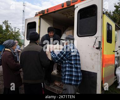 Lyman, Ukraine. 14. Oktober 2022. Freiwillige sahen, wie humanitäre Hilfe in Lyman entladen wurde. Obwohl in der Ostukraine mehr Siedlungen befreit wurden, sind viele große Infrastrukturen nach wie vor durch den Krieg beschädigt. Die Bewohner von Lyman leben ohne Strom, Gas und fließendes Wasser. Die Behörden sind sich nicht sicher, ob sie diese Dienste in naher Zukunft wiederherstellen könnten. Während sich einige Bewohner Sorgen machen, als der Winter naht und mit dem Sammeln von Brennholz begonnen hat, beschlossen einige, in eine nahe gelegene Stadt mit besserer Infrastruktur evakuiert zu werden. Kredit: SOPA Images Limited/Alamy Live Nachrichten Stockfoto