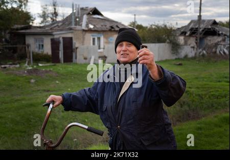 Lyman, Ukraine. 14. Oktober 2022. Eine Bewohnerin von Lyman Seen wollte verzweifelt gefilmt werden und hoffte, dass ihre Verwandten wissen, dass sie lebendig und sicher ist. Die Stadt ist derzeit noch ohne Zugang zum Internet. Obwohl in der Ostukraine mehr Siedlungen befreit wurden, sind viele große Infrastrukturen nach wie vor durch den Krieg beschädigt. Die Bewohner von Lyman leben ohne Strom, Gas und fließendes Wasser. Die Behörden sind sich nicht sicher, ob sie diese Dienste in naher Zukunft wiederherstellen könnten. Während sich einige Bewohner Sorgen machen, als der Winter naht und mit dem Sammeln von Brennholz begonnen hat, beschlossen einige, evakuiert zu werden Stockfoto