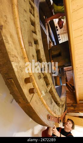 Krostitz, Deutschland. 10. Oktober 2022. Anke und Andreas Hüttner (unten und oben) bereiten sich darauf vor, das mehrere Tonnen schwere Kammrad im Kreativraum und auf dem Boden ihrer Turmwindmühle aus dem Jahr 1883 im nordsächsischen Kupsal zu drehen. Vor vier Jahren tauschten die beiden Finanzbeamten ihre Wohnung in der Großstadt Leipzig im Turm der weißen Windmühle für das Leben ein. (To dpa 'Sleeping Behind Windmill Wings - couple lives in old Mill') Quelle: Waltraud Grubitzsch/dpa/Alamy Live News Stockfoto