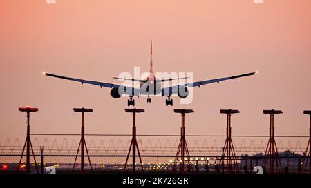 Richmond, British Columbia, Kanada. 16. Oktober 2022. Ein Boeing 777-200ER-Jetliner (G-YMMT) von British Airways landet in der Dämmerung aufgrund von Waldbränden am Vancouver International Airport in rauchigem Dunst. (Bild: © Bayne Stanley/ZUMA Press Wire) Stockfoto