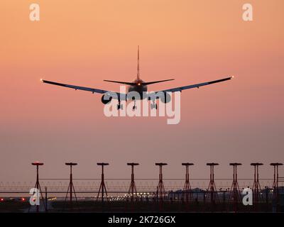 Richmond, British Columbia, Kanada. 16. Oktober 2022. Ein Boeing 777-200ER-Jetliner (G-YMMT) von British Airways landet in der Dämmerung aufgrund von Waldbränden am Vancouver International Airport in rauchigem Dunst. (Bild: © Bayne Stanley/ZUMA Press Wire) Stockfoto