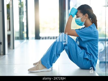 Jede Krankenschwester wurde zur Krankenpflege hingezogen. Eine Krankenschwester, die gestresst aussieht, während sie im Krankenhaus sitzt. Stockfoto