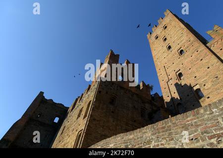 Außenansicht von unten auf die Rocca (Hochburg Burgturm) von Castell’Arquato, mittelalterliches Dorf in der Emilia Romagna, mit blauem klaren Himmel und Sonne Stockfoto