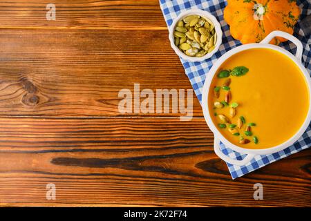 Hausgemachte Kürbissuppe mit Rahm, Kürbiskernen und Basilikum Stockfoto