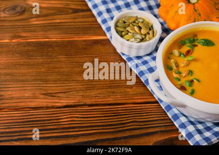Hausgemachte Kürbissuppe mit Rahm, Kürbiskernen und Basilikum Stockfoto