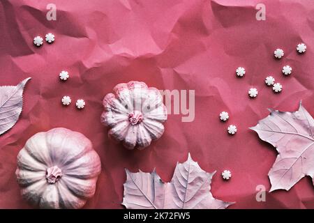 Herbst-Magenta-Hintergrund mit bemalten Ahornblättern, Kürbissen und Reihen von Zuckerstreuseln. Lebendige monochromatische vertikale Kulisse, Geschichten für soziale Stockfoto