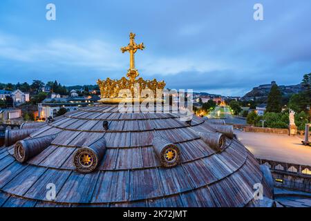 Religiöses Symbol. Goldenes Kreuz und Krone auf der Rosenkranzbasilika in der Wallfahrtskirche von Lourdes, Frankreich bei Sonnenaufgang Stockfoto