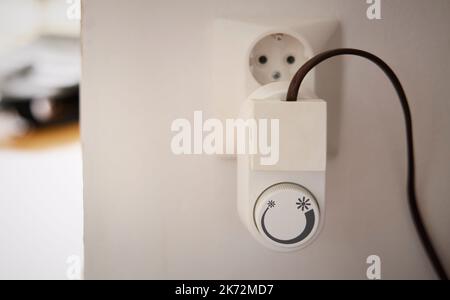 Thermostatstecker in Wandsteckdose Stockfoto