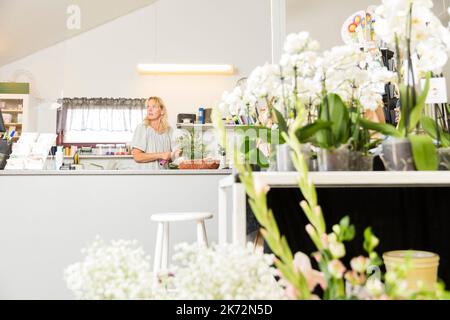 Frau arbeitet im Blumenladen Stockfoto