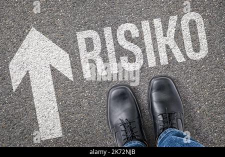 Text auf dem Boden - Risiko auf deutsch - Risiko Stockfoto