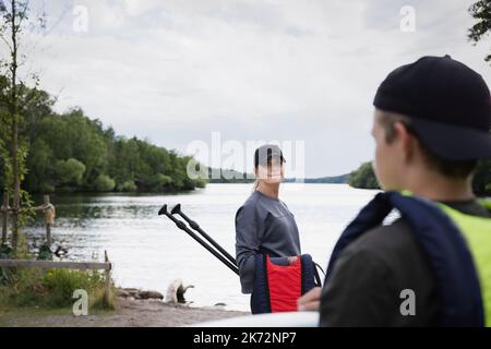 Mutter und Sohn bereiten sich auf das Paddelboarden vor Stockfoto