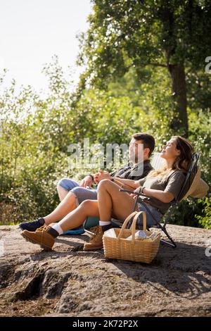 Pärchen sonnen sich auf Liegestühlen Stockfoto