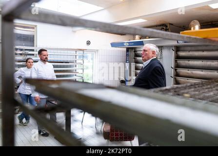 Lengerich, Deutschland. 17. Oktober 2022. Karl-Josef Laumann (r) (CDU), Minister für Arbeit, Gesundheit und Soziales des Landes Nordrhein-Westfalen, besucht eine Bäckerei und tauscht sich über hohe Energiekosten und die Sicherung von Fachkräften aus. Auf der linken Seite befinden sich die Bäckermeister Pascal und Christina Klinker. Die Bäckerei ist seit 1911 im Geschäft und beliefert ihre fünf Fachgeschäfte, Schulen, Kindergärten, Seniorenheime und Restaurants mit Backwaren. Quelle: Guido Kirchner/dpa/Alamy Live News Stockfoto