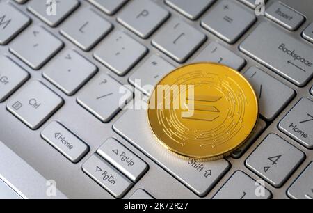 Solana einzelne goldene Krypto-Münze auf grauer Tastatur, Nahaufnahme, Kopierraum. Stockfoto