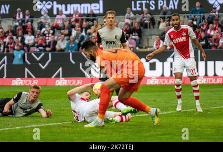 Köln, Nordrhein-Westfalen, Deutschland. 16. Oktober 2022. FC Augsburg-Torwart Tomas Koubek (40) spart sich vor den FC Köln-Spielern STEFFEN TIGGES (21) und LINTON MAINA (37, ganz rechts) beim Bundesliga-Spiel des FC Köln gegen den FC Augsburg am 16. Oktober 2022 im RheinEnergieStadion in Köln. (Bild: © Kai Dambach/ZUMA Press Wire) Stockfoto