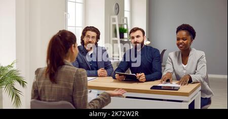 Ein multirassisches Team aus drei Personalmanagern, die einen Kandidaten im Büro befrachten Stockfoto