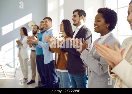 Das Happy Office-Team zeigt Freude an der Geschäftsschulung, indem es den Sprechern freudig applaudiert. Stockfoto