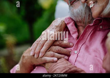 Nahaufnahme der streichelenden Hände eines verliebten älteren Paares. Stockfoto