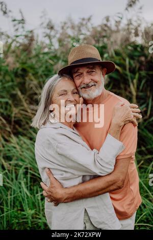 Porträt eines verliebten älteren Ehepaares, das in der Natur draußen steht. Stockfoto