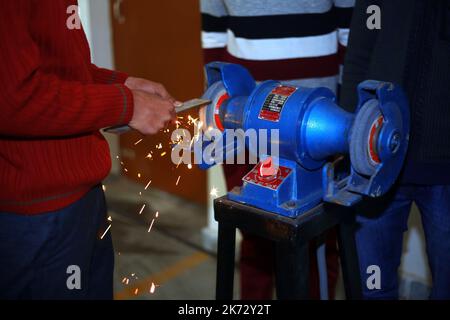 Mann, der arbeitet, Eisen, Maschine, Mühle, Grinder Funken, Maschinenarbeit, Eisenschleifer, Schleifmaschine, Metallschleifer, Winkelschleifer, Funken, Werkstatt, Gebäude, Baumeister Stockfoto