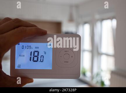 Nahaufnahme des Thermostat-Heizungsbedienfelds mit Heizung im Hintergrund im Kühlraum aufgrund von Gaseinschränkung und Energiekrise Stockfoto